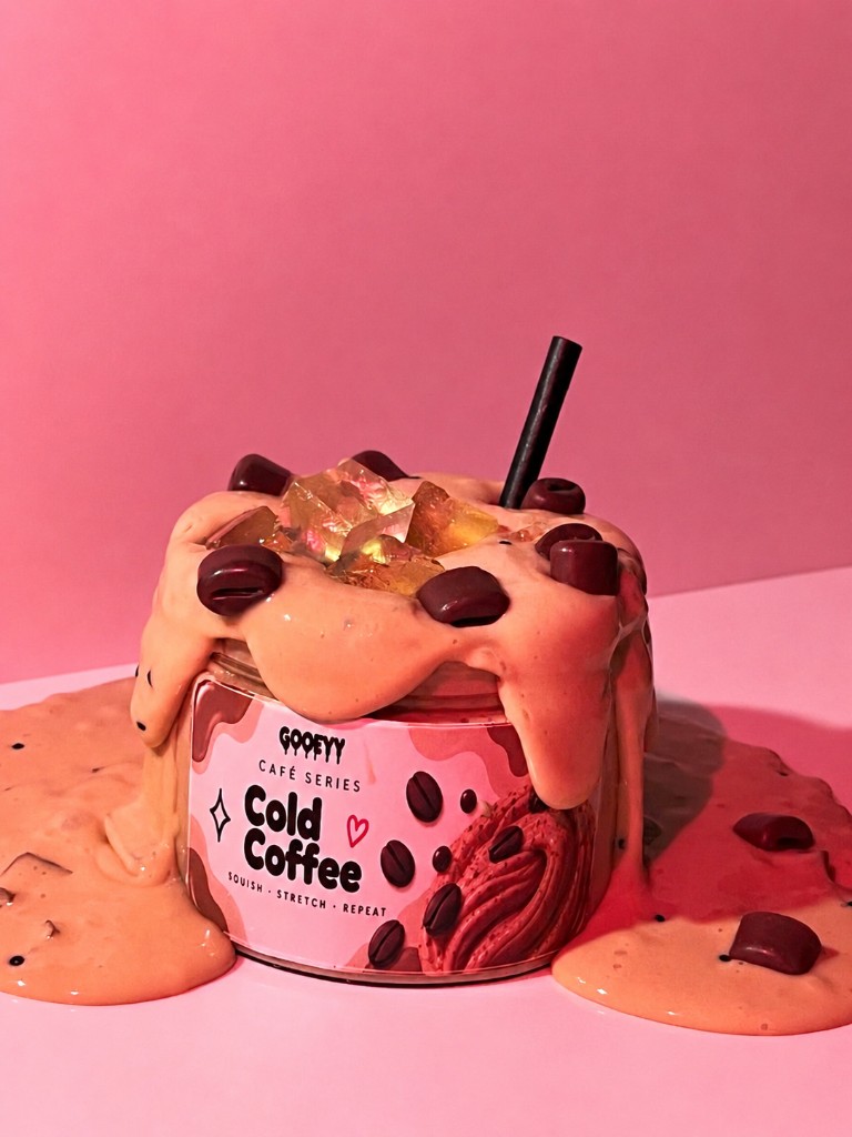 Cold Coffee slime jar overflowing with cream, ice cubes and coffee beans