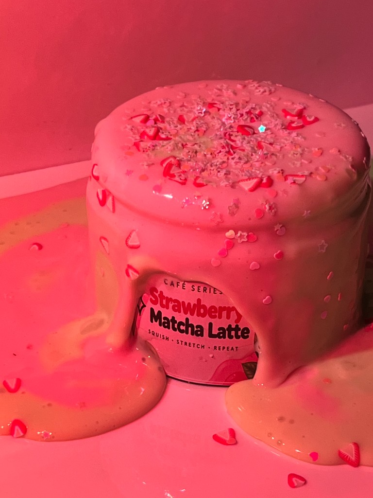 Strawberry Matcha Latte slime jar overflowing with pink cream and sprinkles